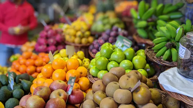 Étal de fruits colorés au marché : agrumes, pommes, bananes